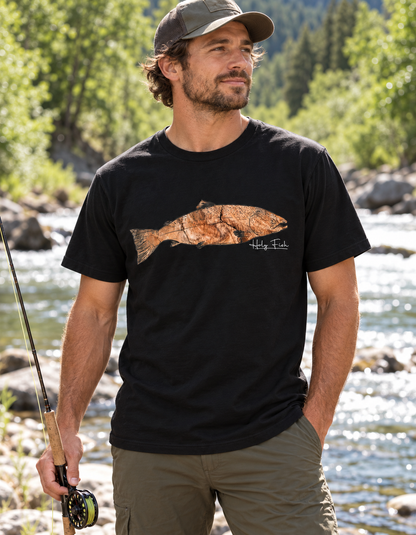 Forellenangler trägt schwarzes Holy Fish M11 Forellen-T-Shirt am Fluss