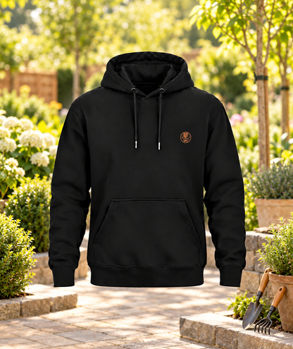 Schwarzer Galabauer Hoodie mit kleinem Brustwappen in einer Gartenbaukulisse