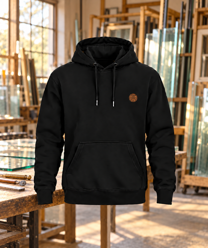 Schwarzer Glaser Hoodie mit kleinem Brustwappen in einer Glaswerkstatt